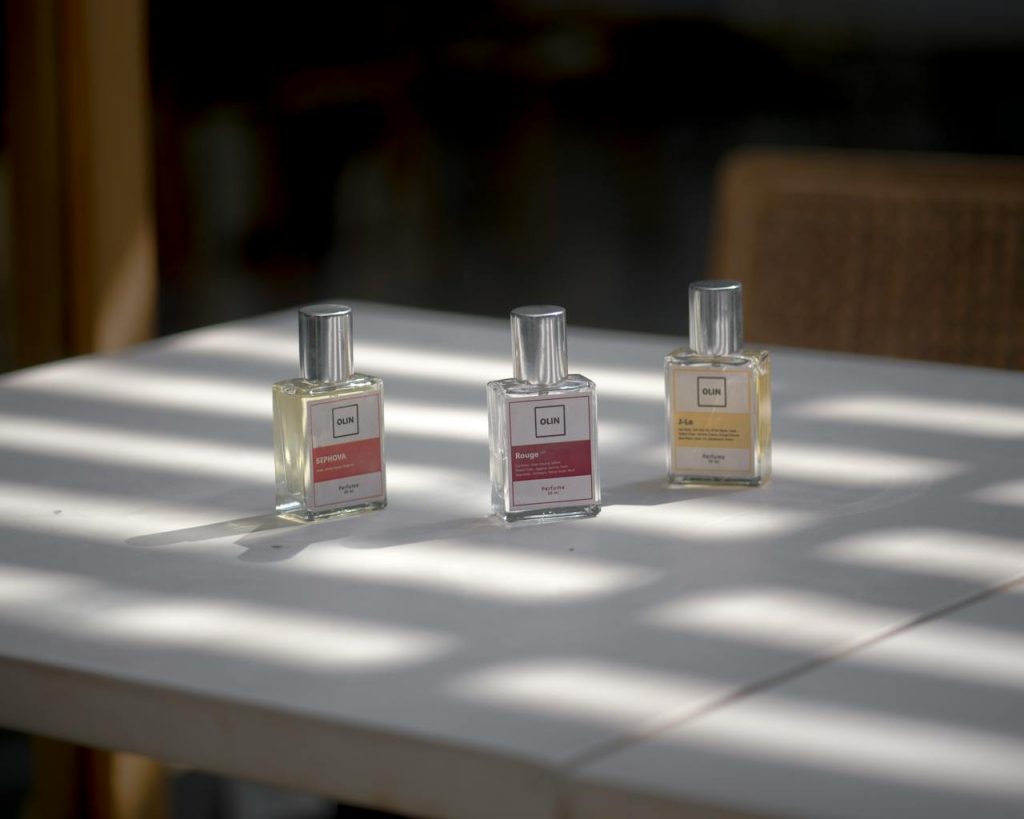 Three elegant perfume bottles arranged on a sunlit table, capturing the essence of fragrance and style.